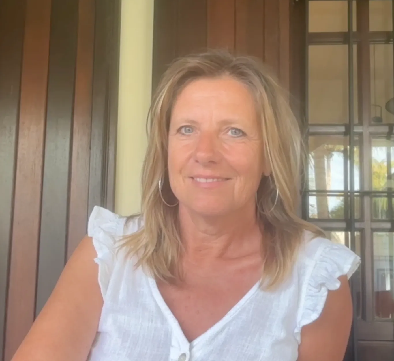 Portrait de Nathalie Le Quéméner, souriante, en chemisier blanc